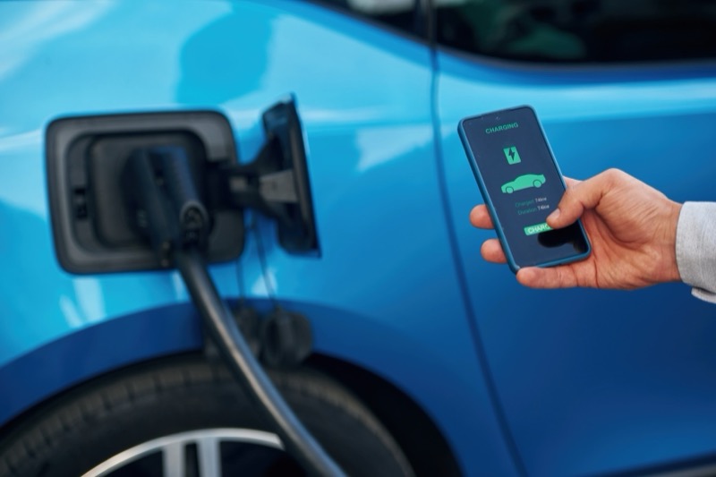 Smarte Wallbox an der Garagenwand mit Smartphone-App zur Ladesteuerung