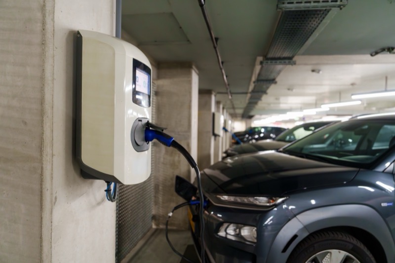 Electric vehicle recharging at a public charging station in a shared parking area
