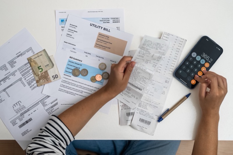 Woman reviewing bills and calculating potential EV charger rebate savings