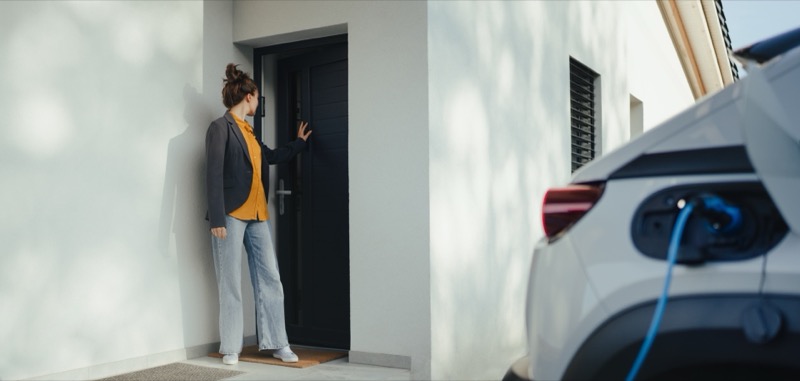 Young woman charging her Hyundai Ioniq 5 at home with a Level 2 wall charger